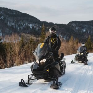 Deux motoneigistes en randonnée guidée sur un sentier de la Haute-Mauricie